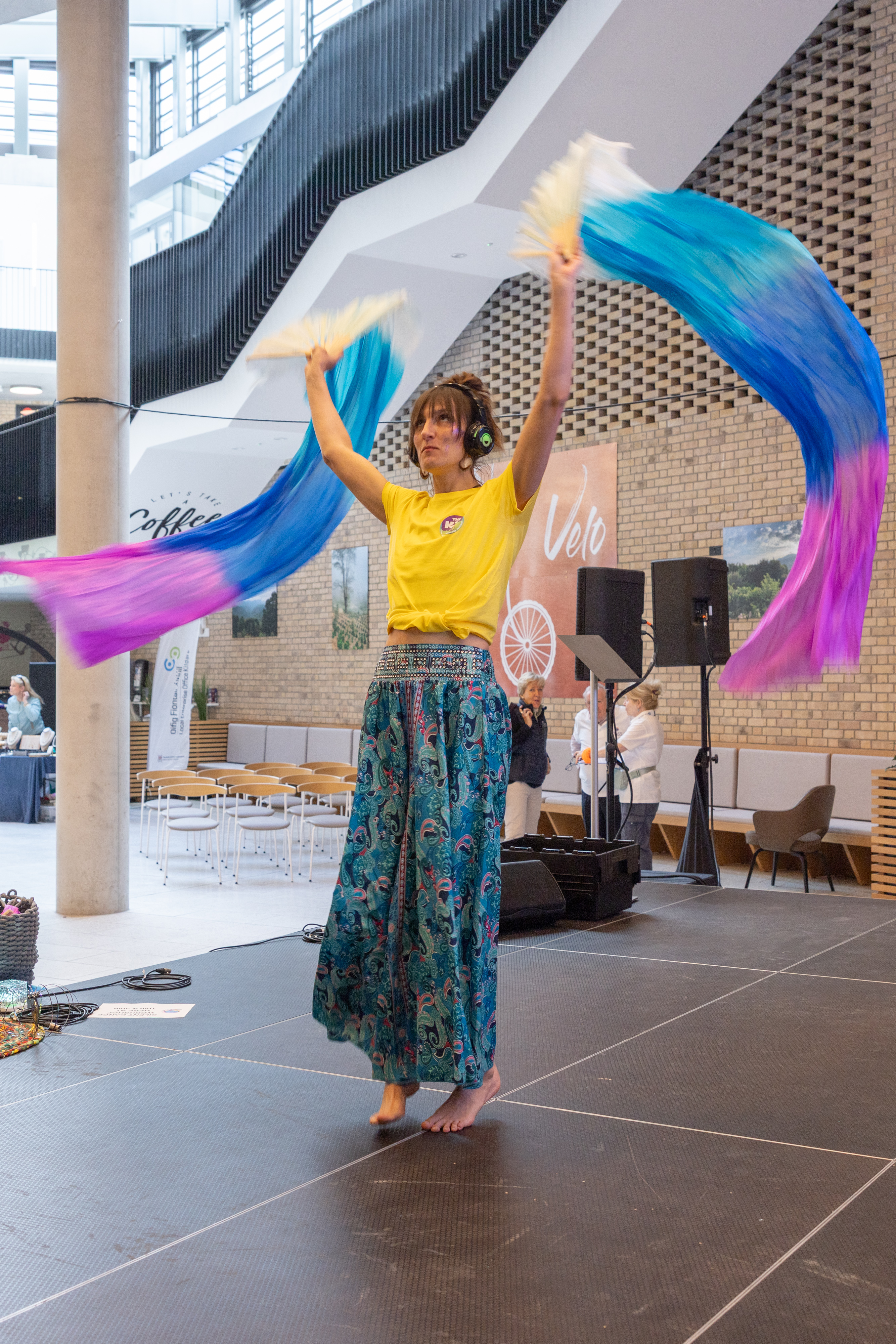 Person moving colourful fabric.